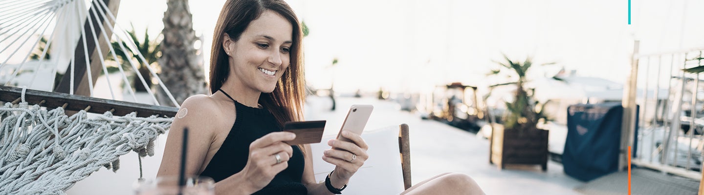 Woman on vacation looking at credit card and phone
