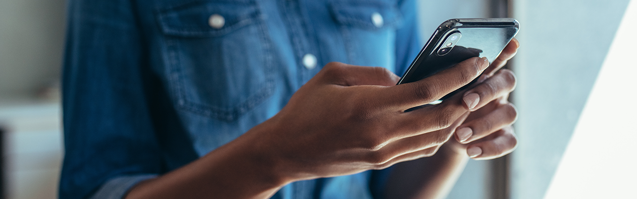 Close up of a Black woman holding a phone.