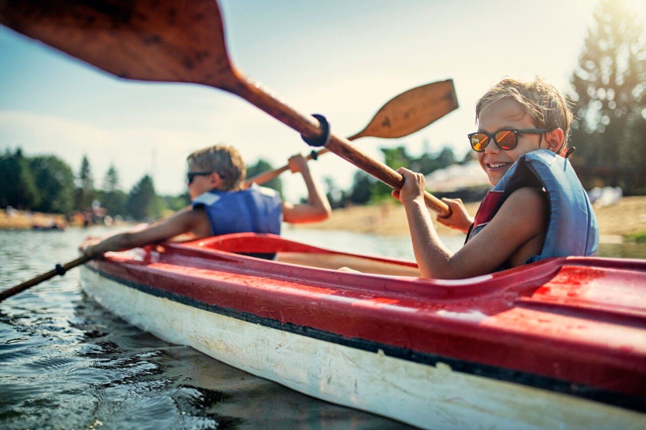 Two boys enjoying kayaking on lake