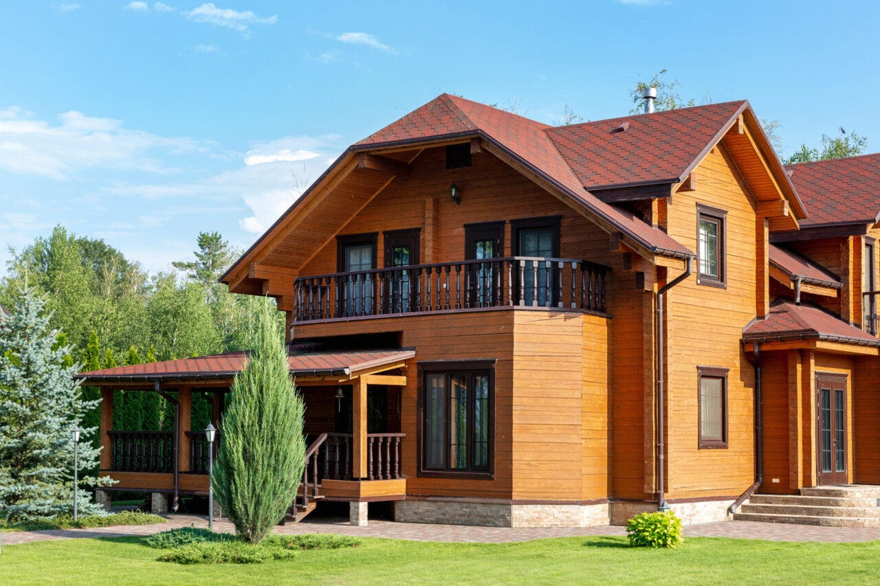 Large luxury wood home with asphalt shingles.