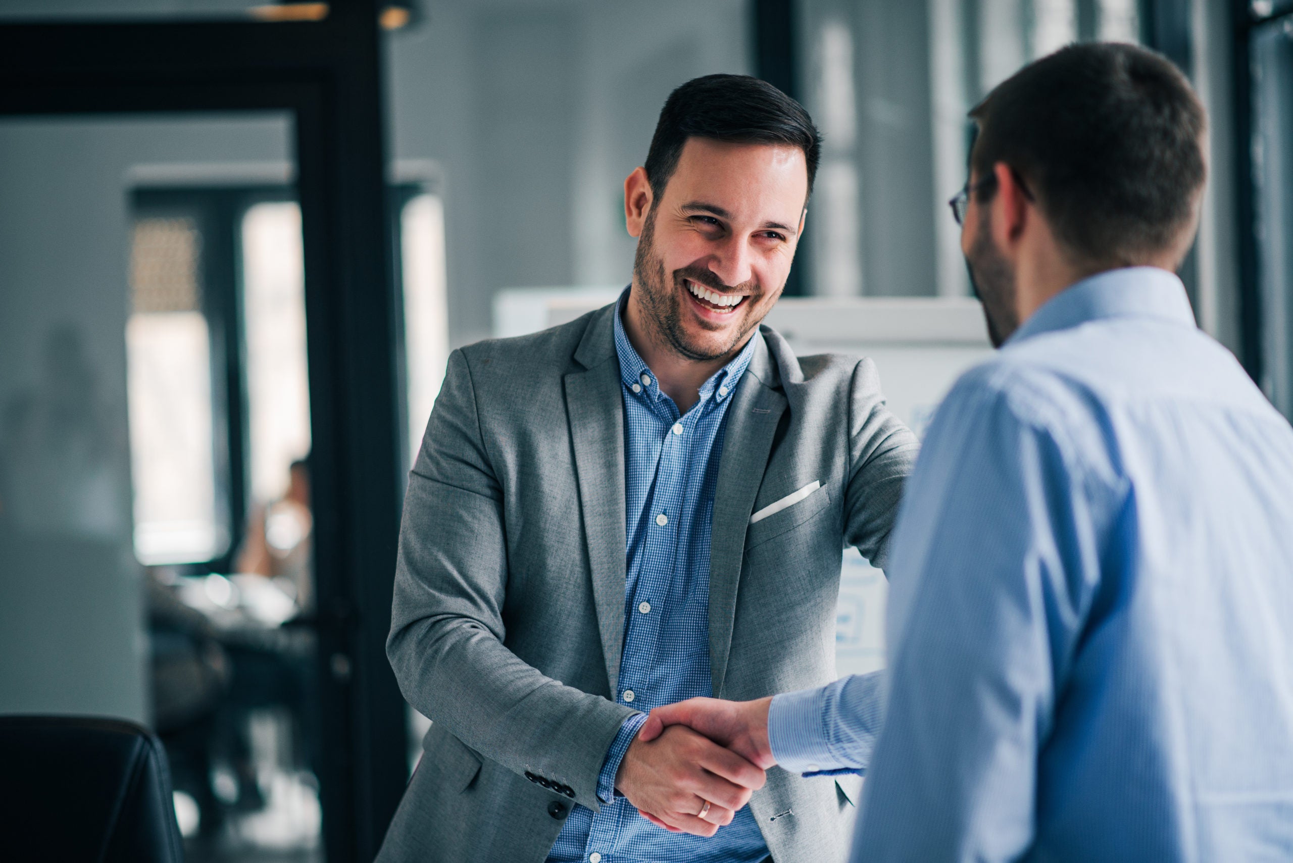 Happy businessman shaking the hand of a client.