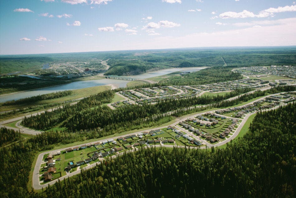 View of Fort McMurray, Alberta in the middle of a forest next to a lake.