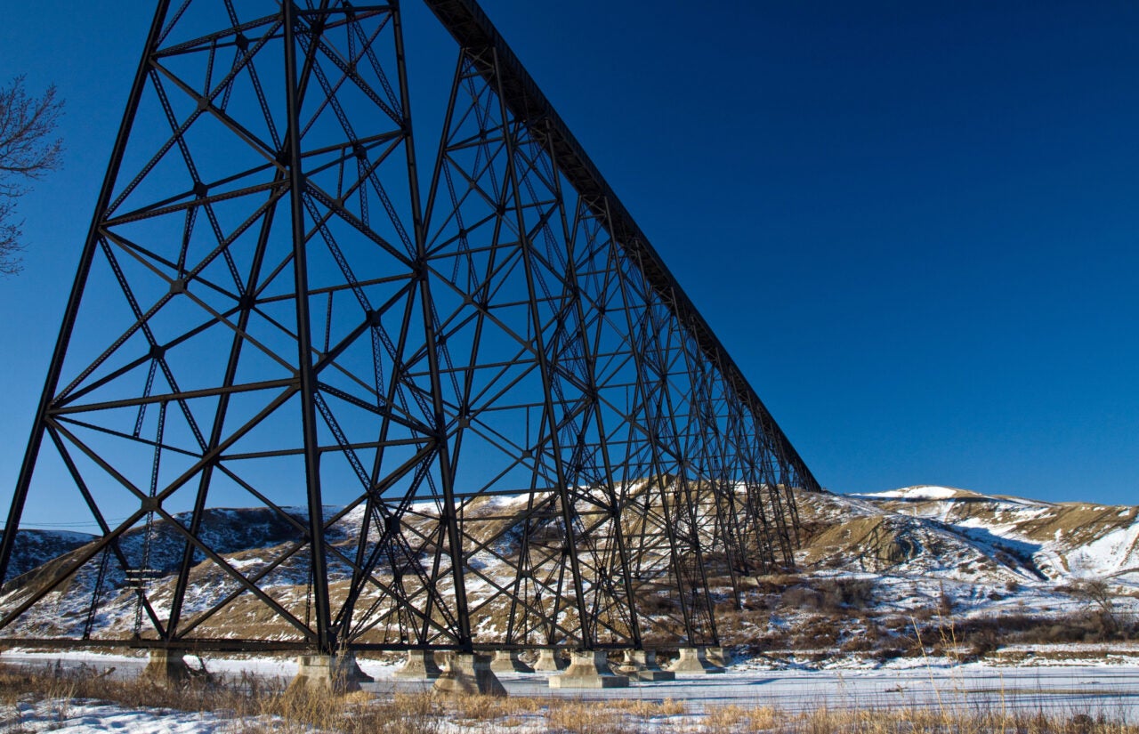 View of a high level rail bridge on a blue sky background seen from below near Lethbridge, Alberta, Canada.