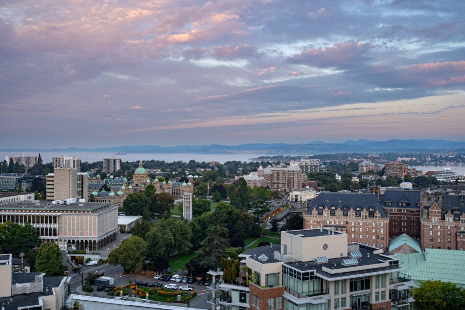 Aerial view of downtown Victoria, BC. A colourful cloudy sunrise overhead.