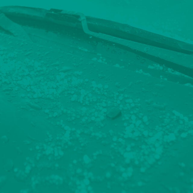 Pieces of hail that have fallen on a car windshield