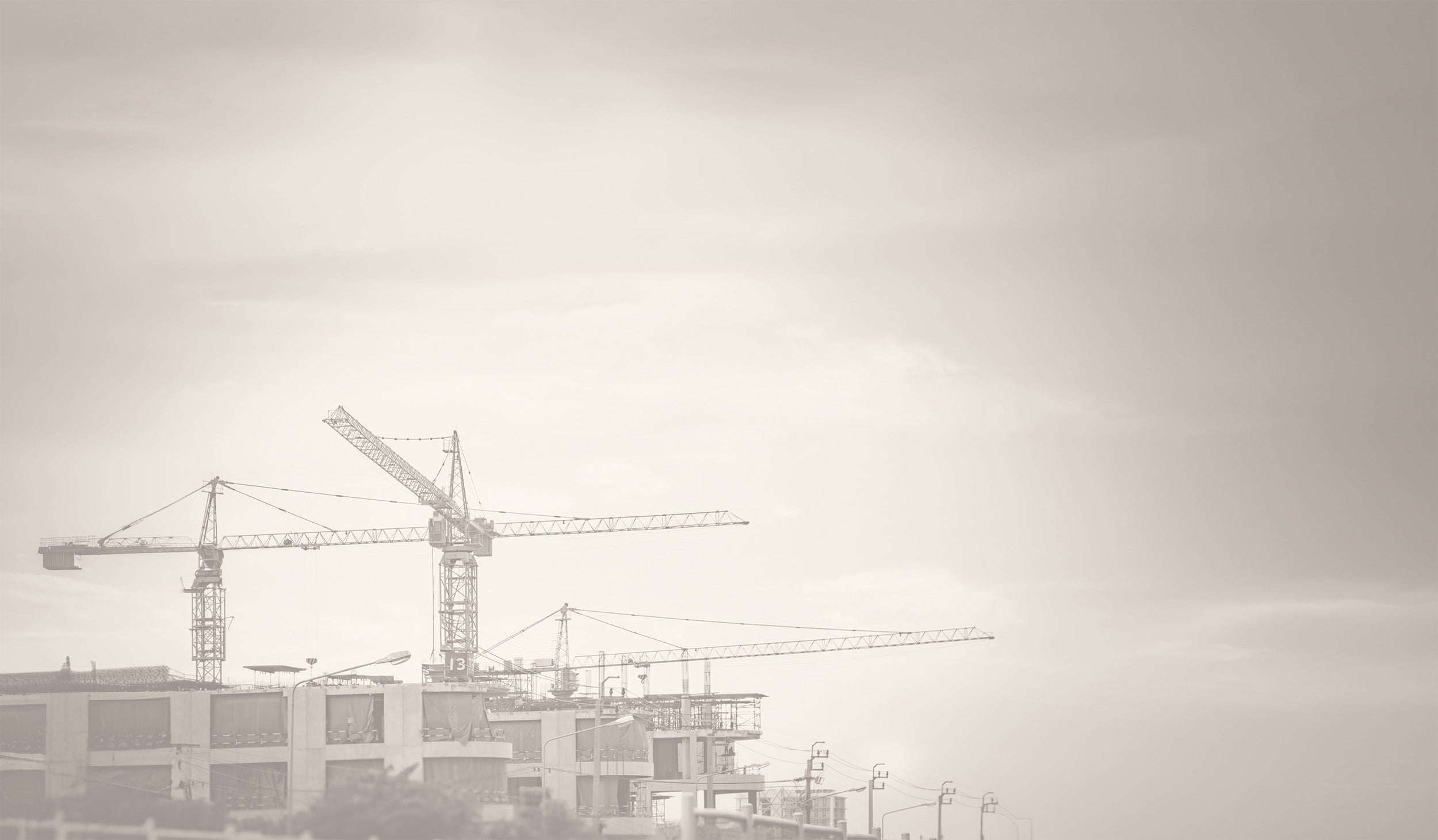 View of top of three cranes against the sky at a construction site