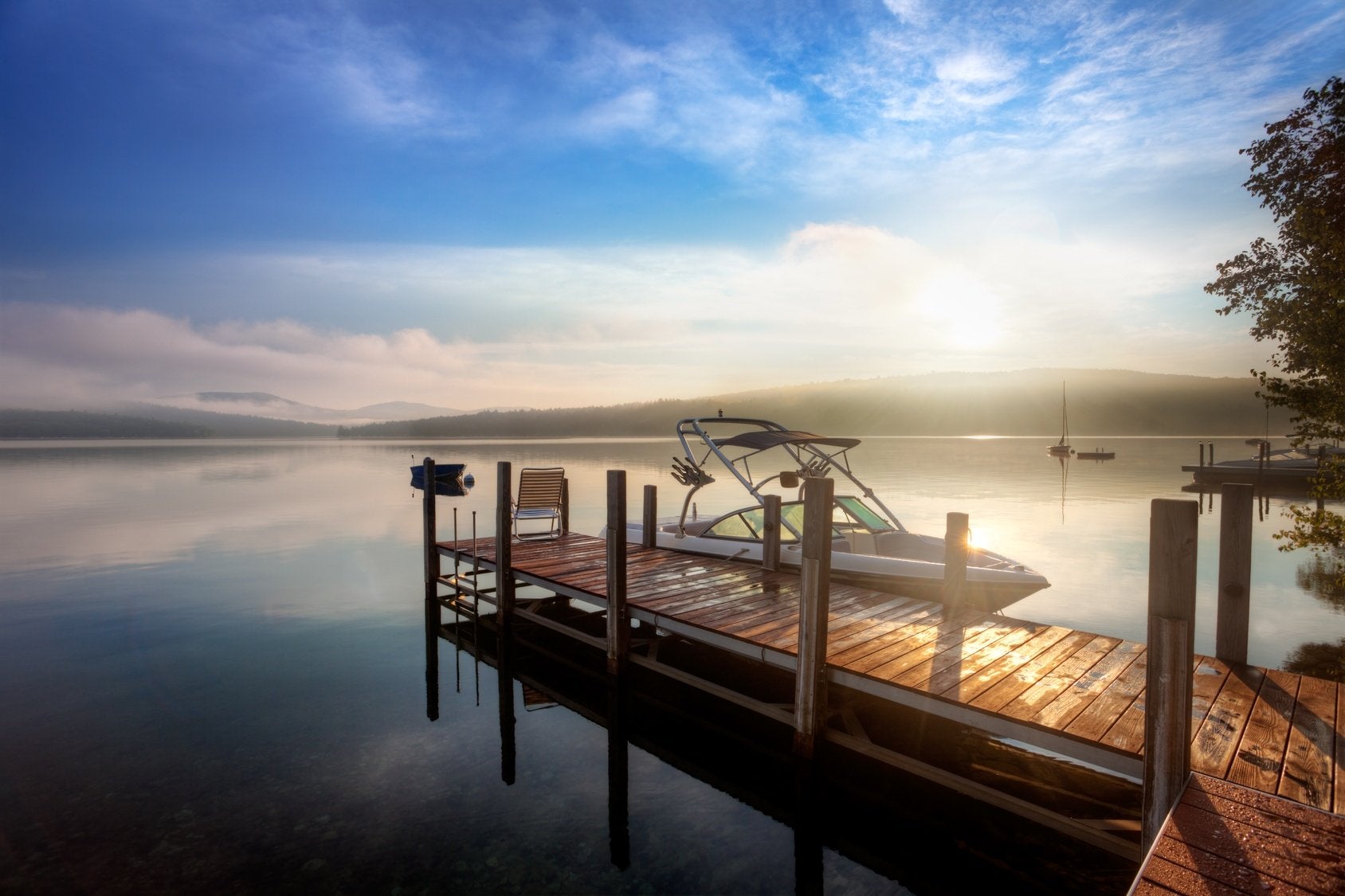 Boat tethered to a wooden dock on a misty lake