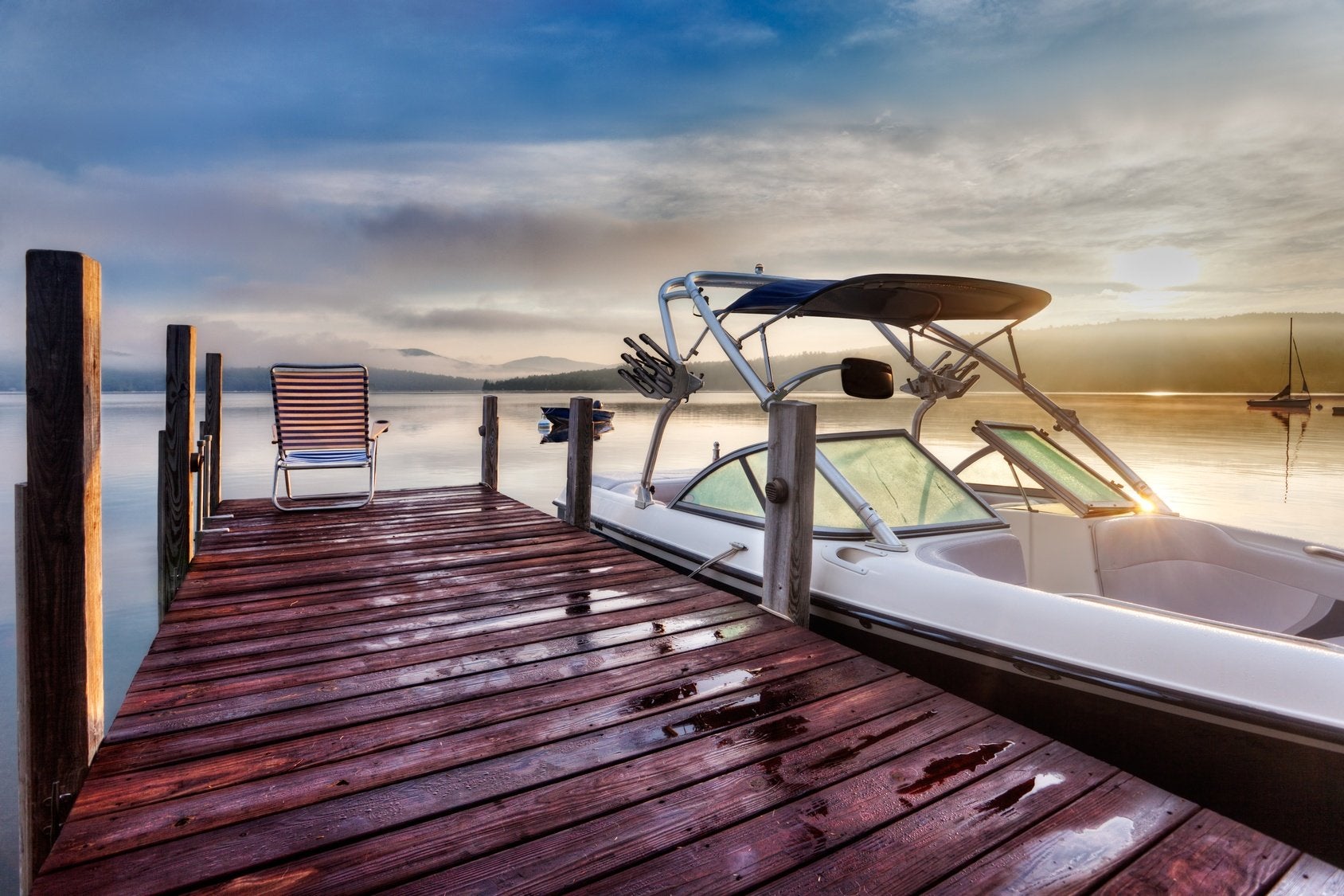 Boat tethered to a wooden dock at sunset