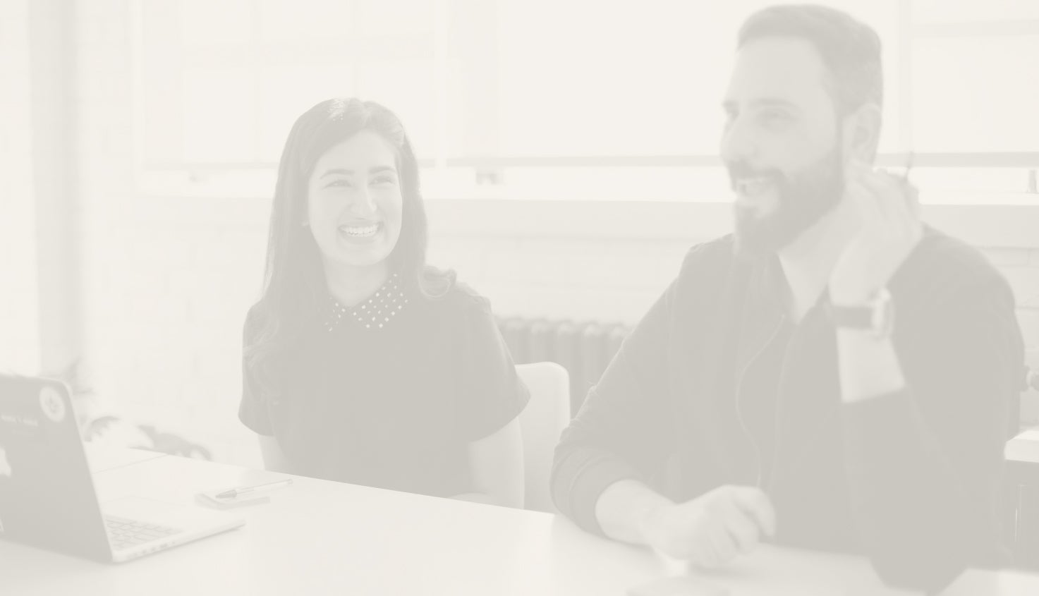 Two employees looking at each other and laughing