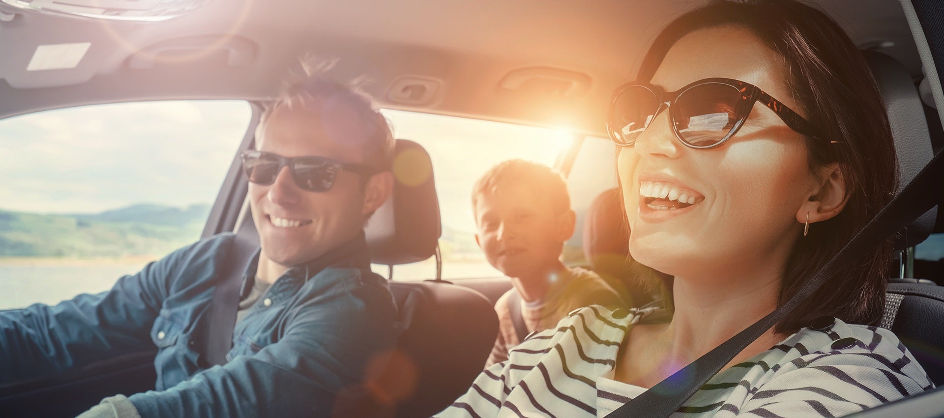 Young family in car smiling