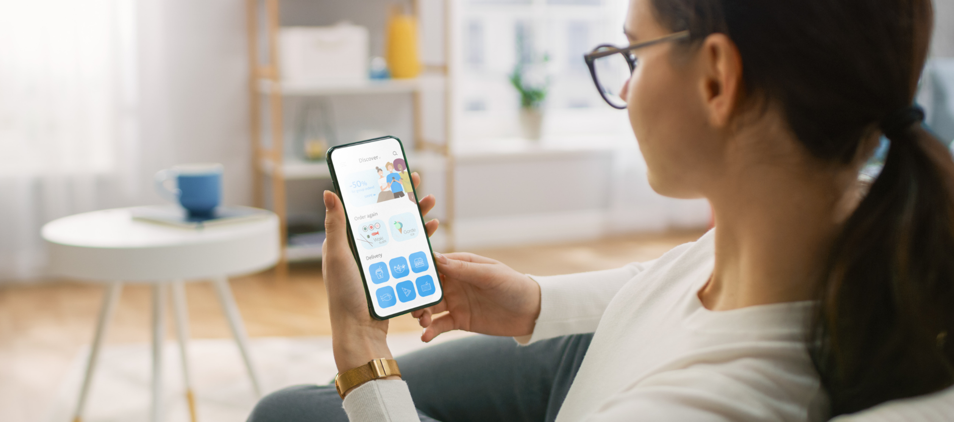 Woman looking at her cellphone while sitting on a couch