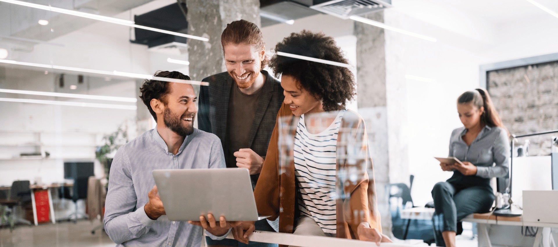 Employees in an office looking something on a computer