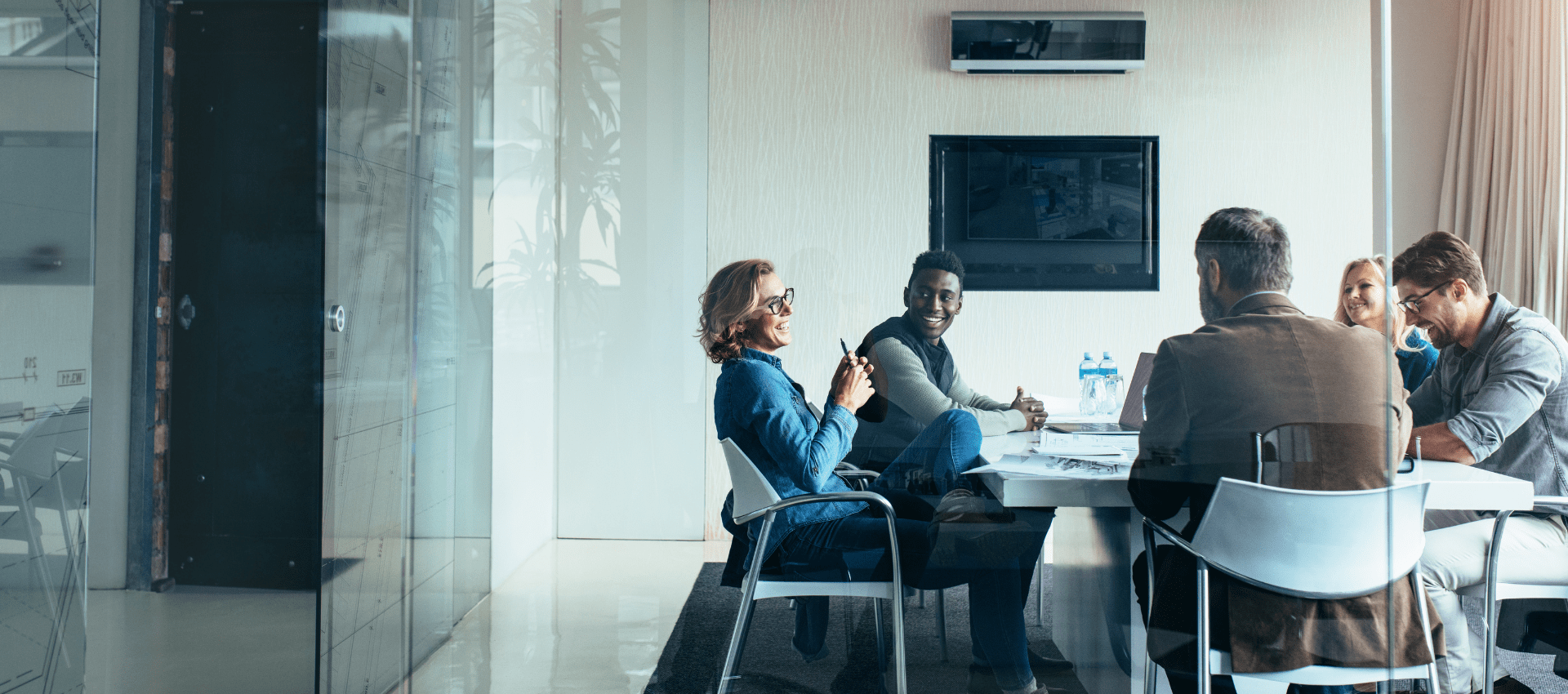 Group of professionals sitting around a table having a discussion in a boardroom