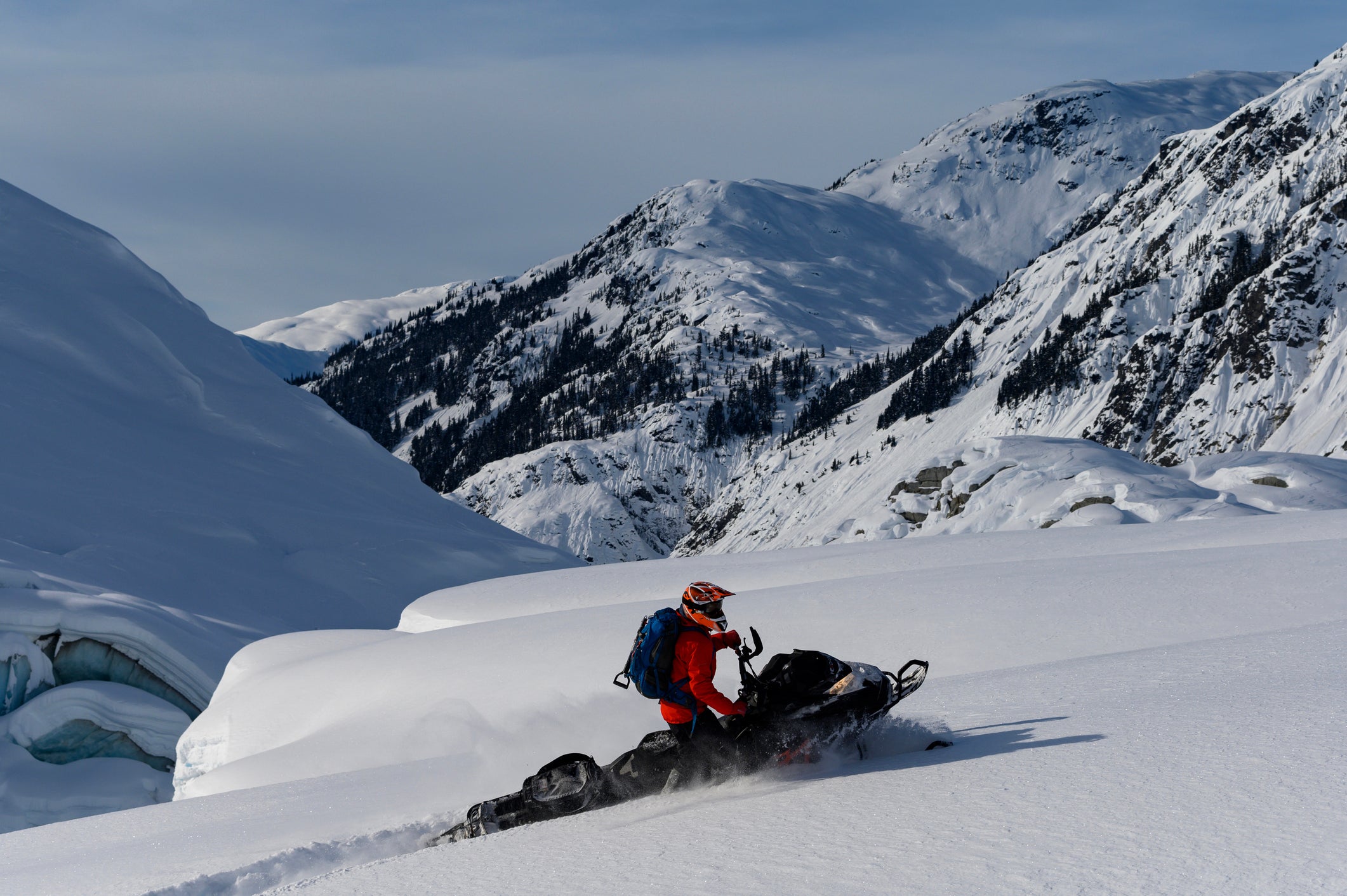 Backcountry snowmobiler rides across glacier through fresh powder snow, Whistler
