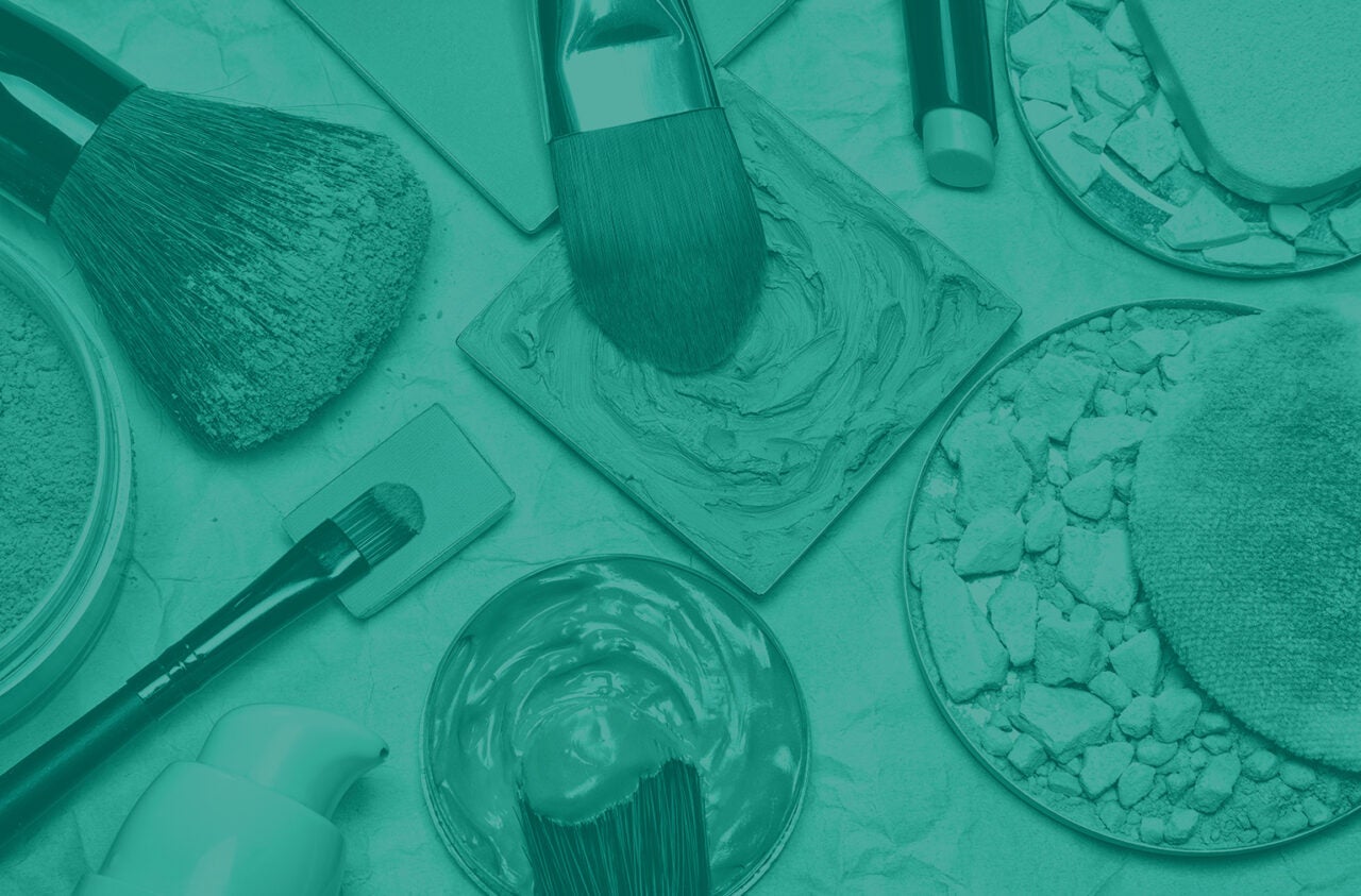 Top view of a bunch of makeup products and brushes on a counter