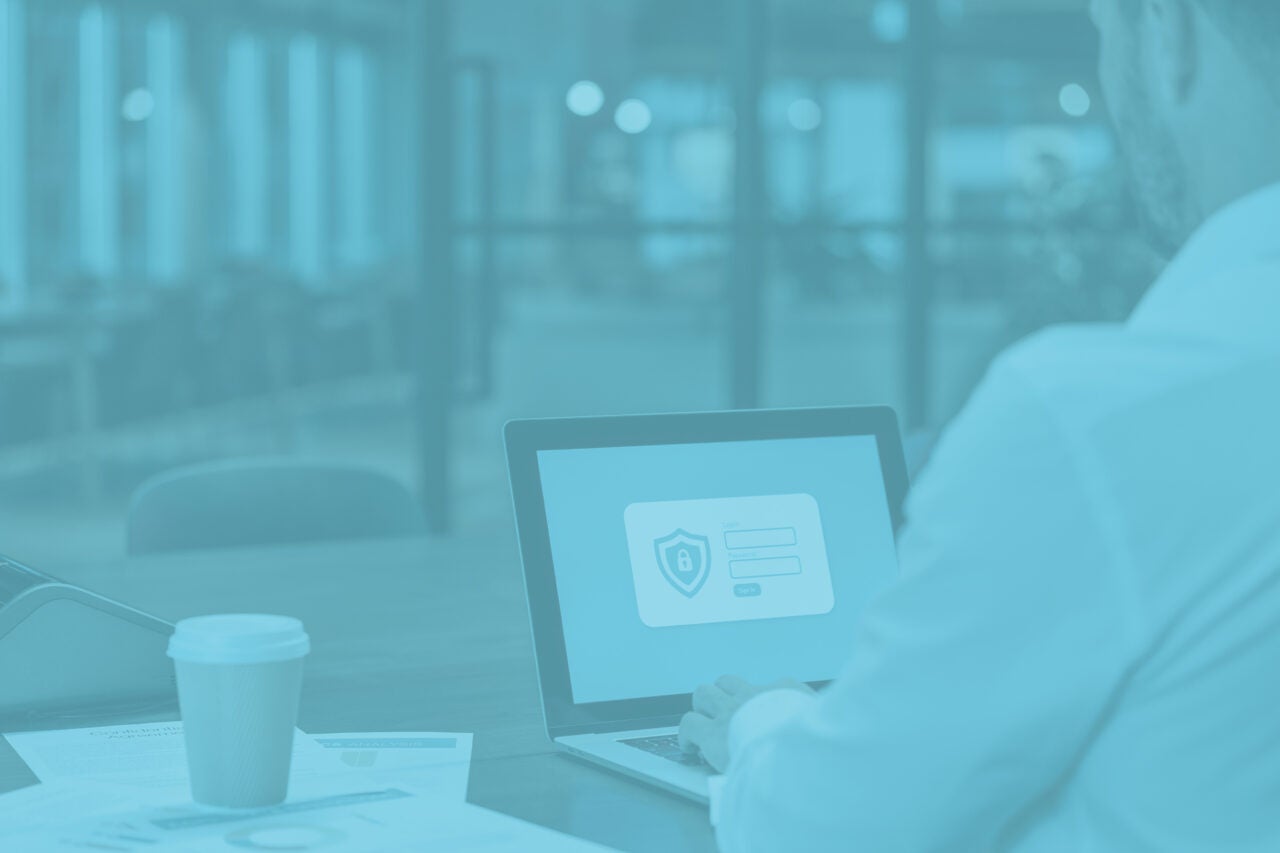 Cyber security charts on a laptop screen with a person facing away looking at the screen